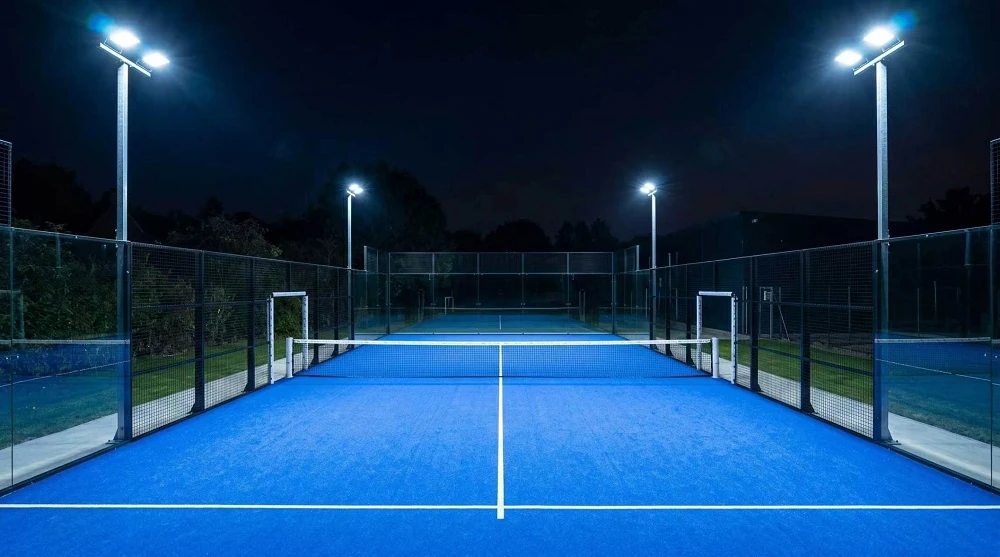 illuminated panoramic padel court at night, glass enclosed paddle tennis court